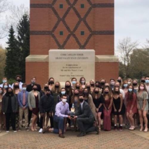 Rowing team poses in front of clocktower following banquet.